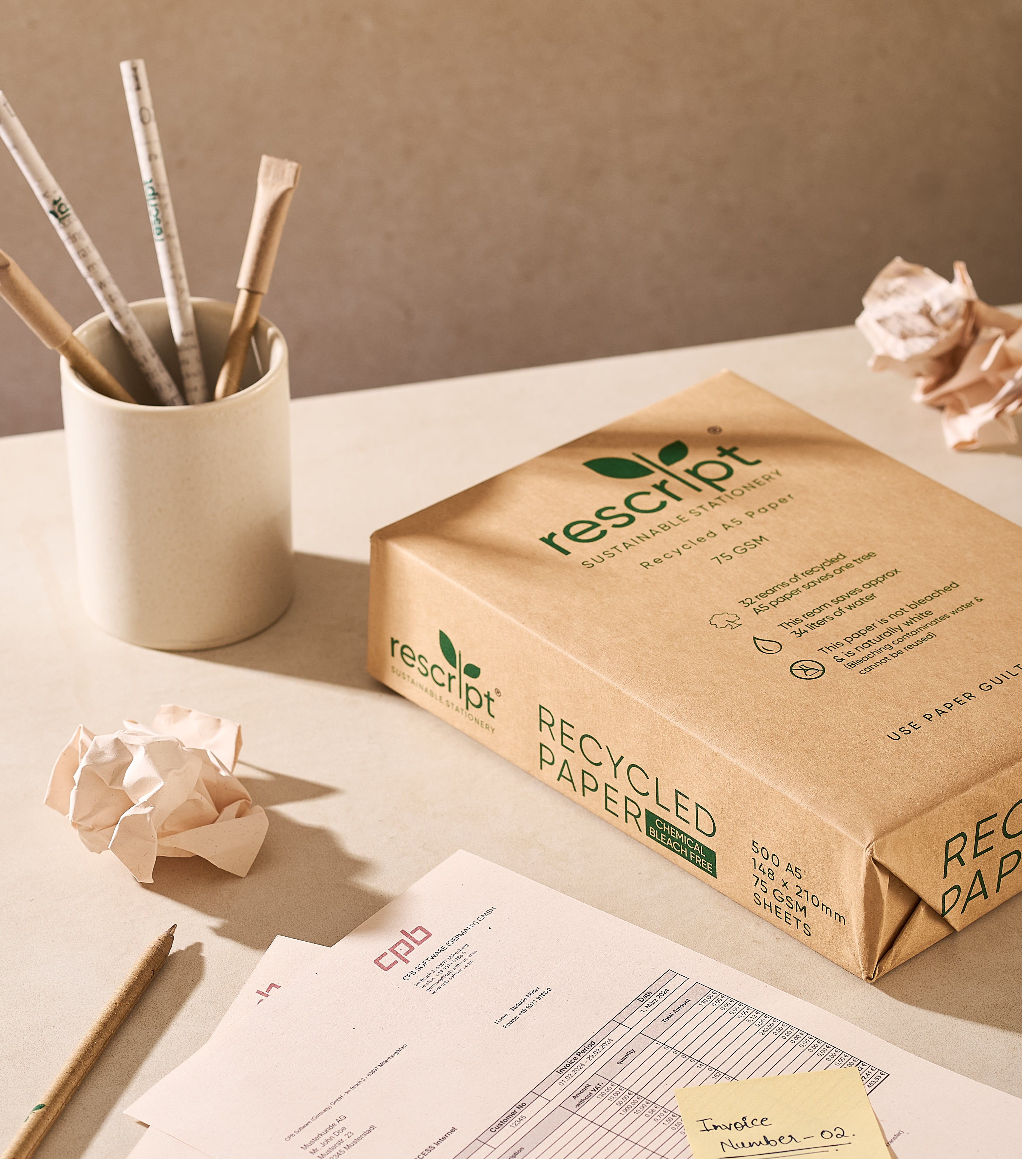 Box of rescript recycled paper on a desk with stationery items
