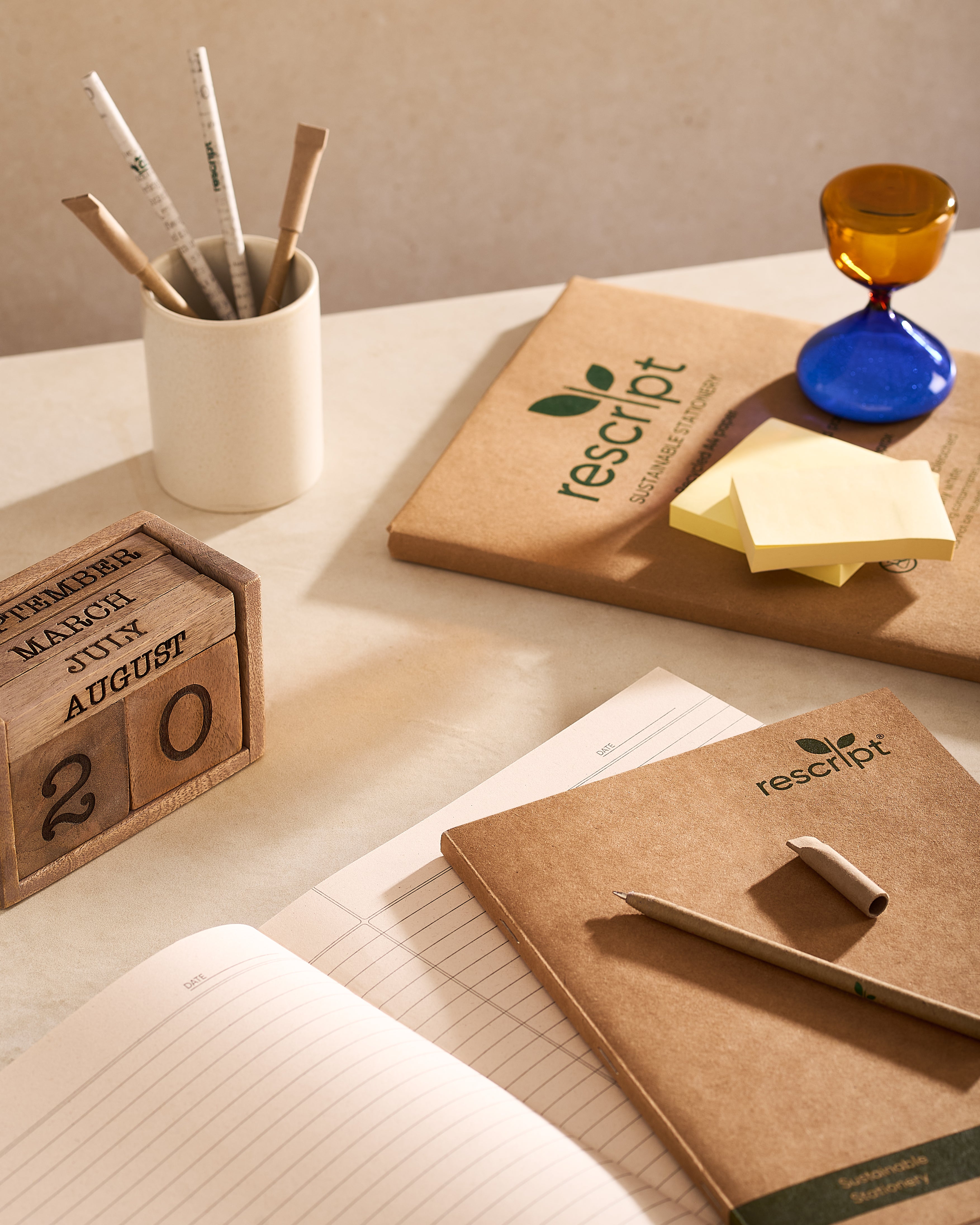 Desk setup with rescript notebooks, pens, and a calendar.
